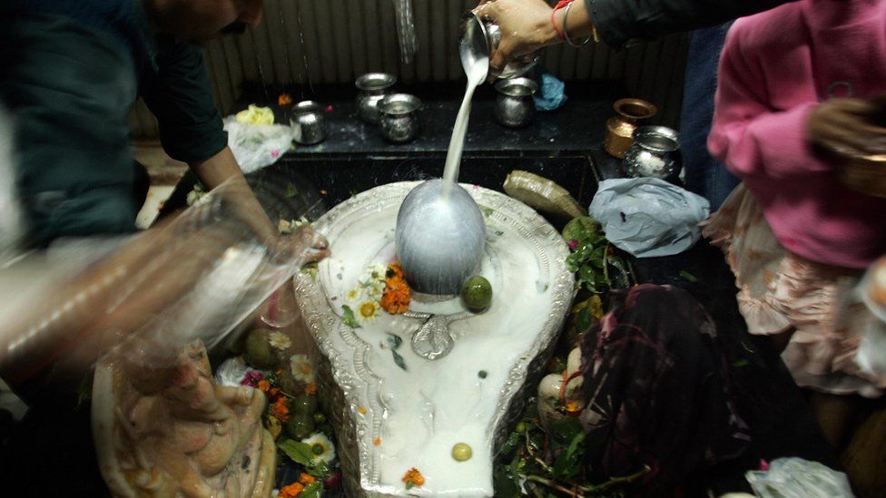 Devotees pour milk on to a shiva lingam