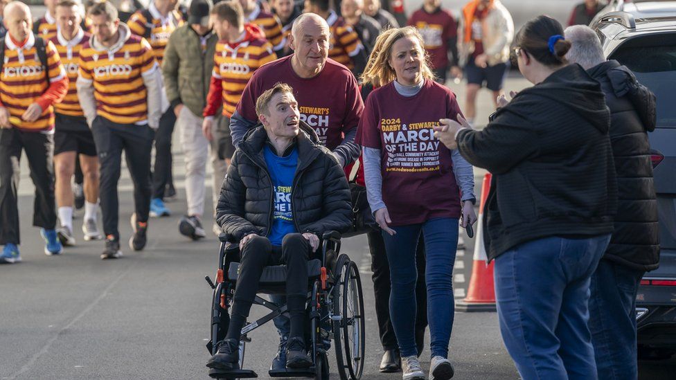 Former football player Stephen Darby, who has been diagnosed with motor neurone disease, setting off from Bradford City Football Club's Valley Parade stadium for the 'March of the Day' trek