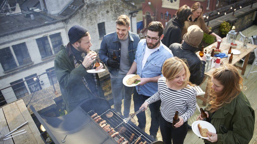 Young people enjoy a barbecue on a rooftop
