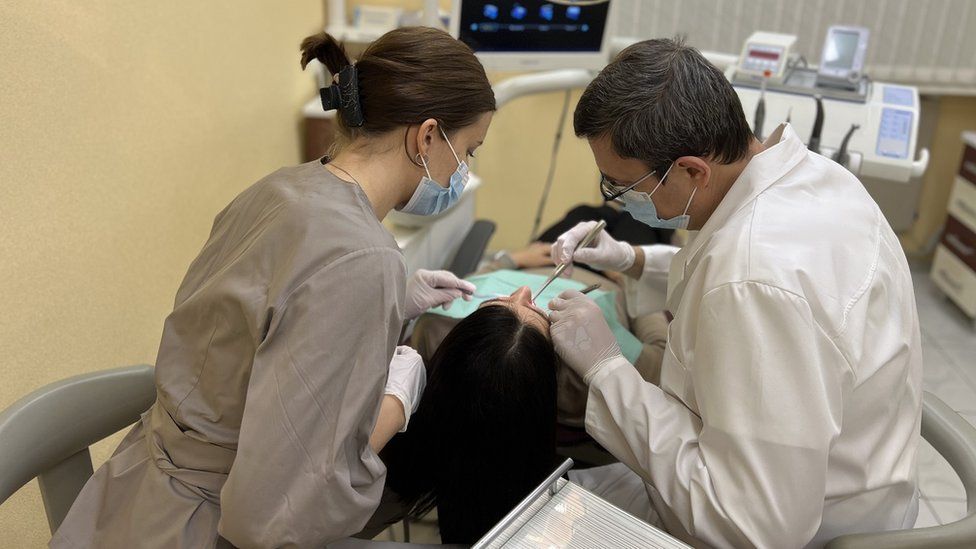 Two dental professionals treating a patient in Dnipro in Ukraine