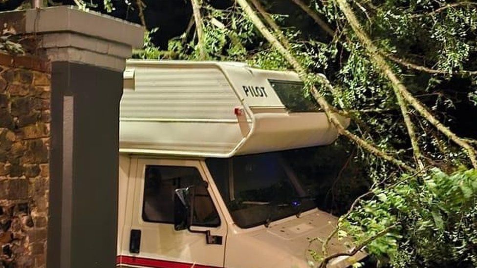 The roof of a motorhome pierced by the branches of a tree torn