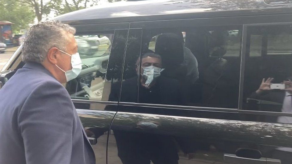 Man wearing a mask entering a taxi