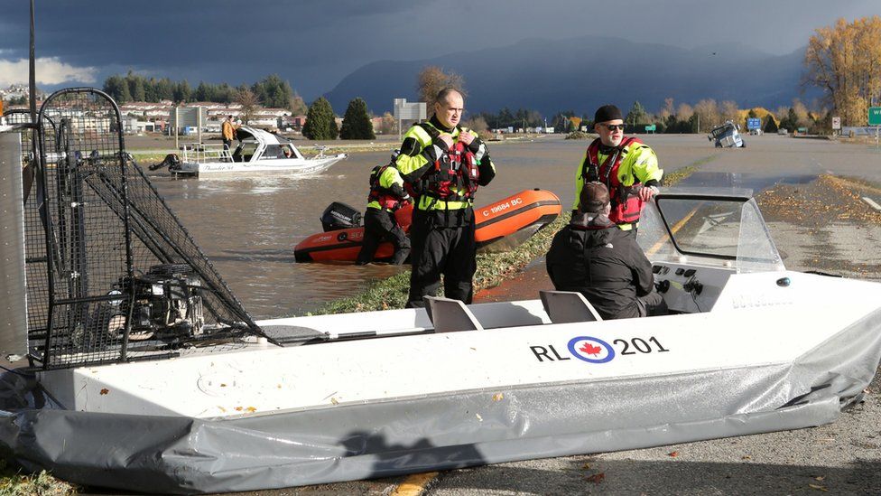 Members of a search and rescue team speak with the pilot of a hovercraft parked on the flooded Trans-Canada Highway after rainstorms caused flooding and landslides in Abbotsford, British Columbia, Canada November 16, 2021.