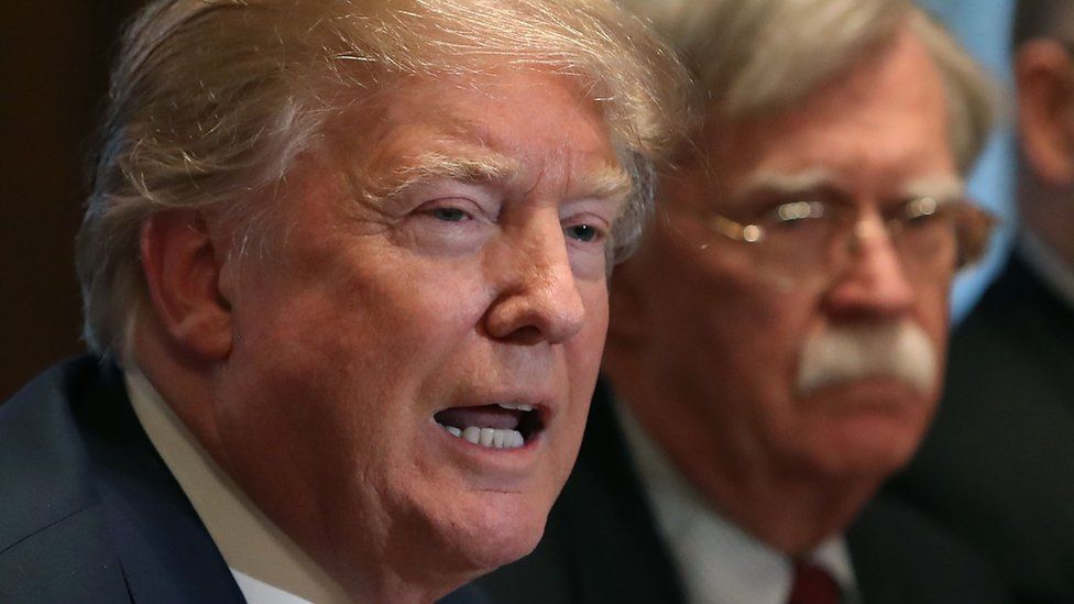 U.S. President Donald Trump is flanked by National Security Advisor John Bolton as he speaks about the FBI raid at his lawyer Michael Cohen"s office,