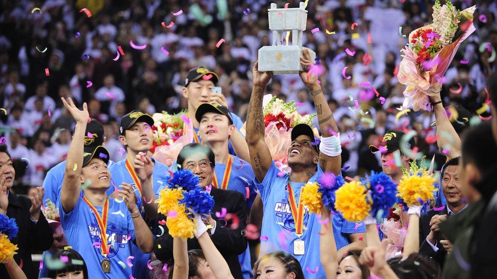 Stephon Marbury holds up the trophy as he celebrates with his team, the Beijing Ducks, as they win their first-ever Chinese championship