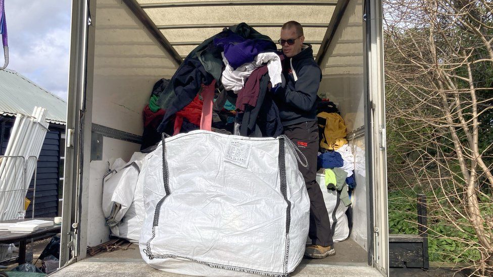 Clothes being moved into large tonne bags in a white van, ready to be donated