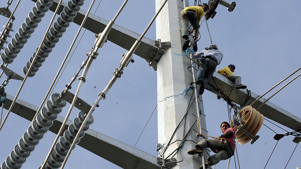 Linemen install cables on the Transco power transmission line in Santa Rosa town south of Manila on January 15, 2009