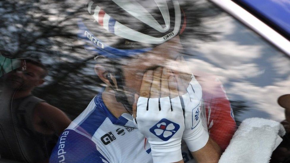 France's Thibaut Pinot, in his team car, reacts after quitting the Tour