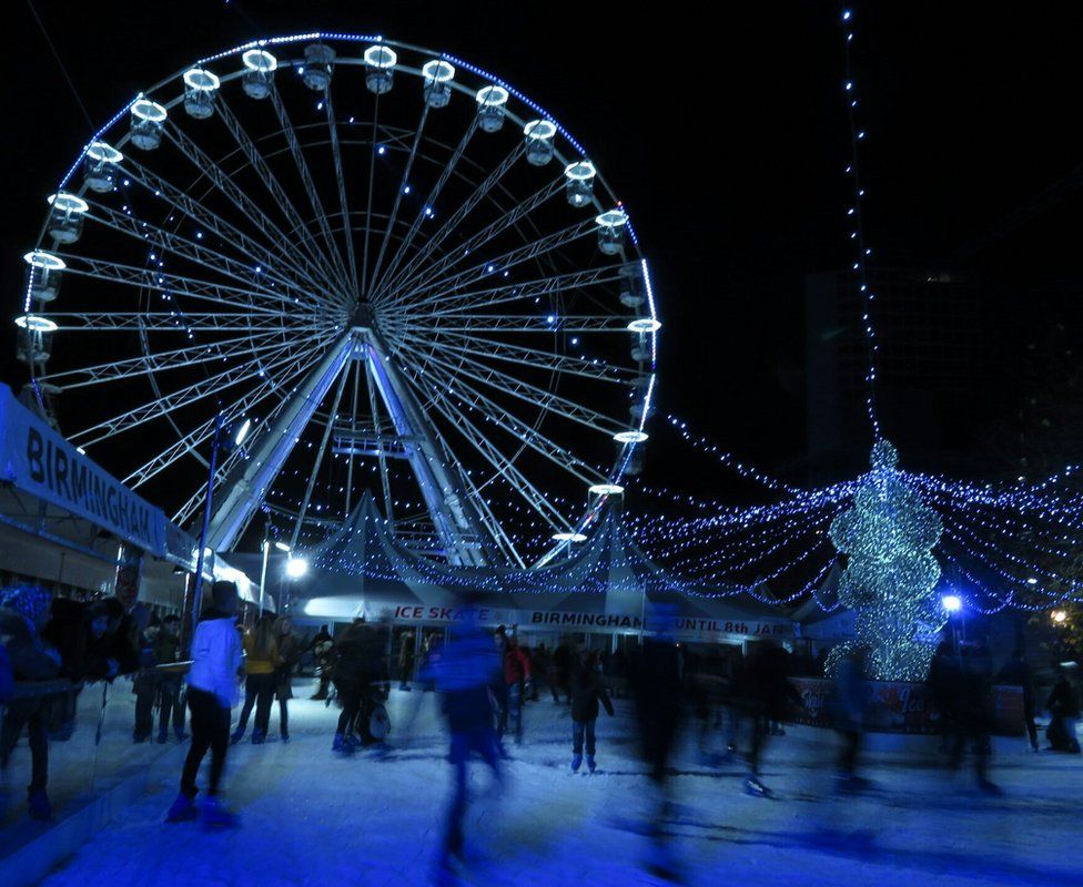 Ice skaters and a big wheel lit blue