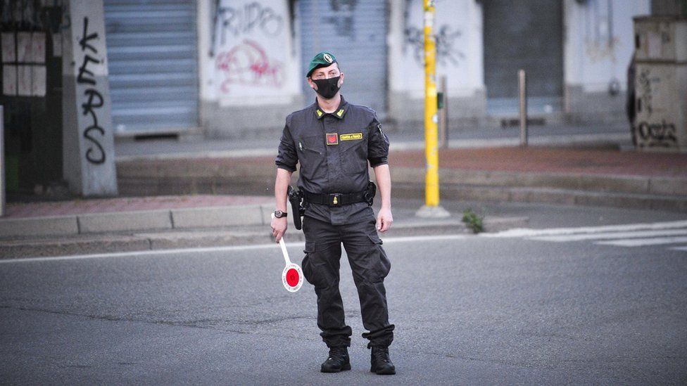 Italian Guardia di Finanza officers wearing protective face masks man a checkpoint between Corvetto and Rogoredo in Milan