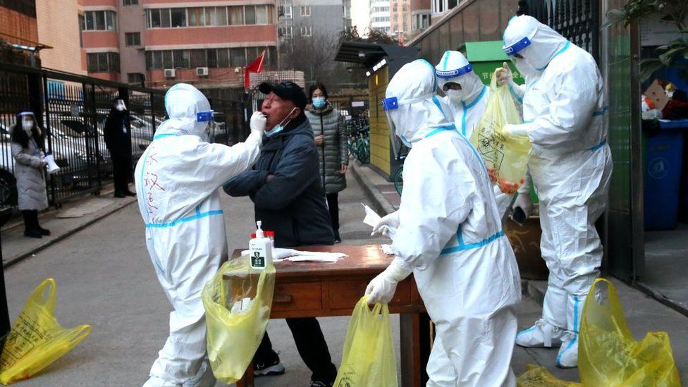 Mitarbeiter in Schutzanzügen führen am 2. Januar 2022 in Xi'an, Provinz Shaanxi, China, in einem Wohngebiet COVID-19-Kernsäure-Tests durch.