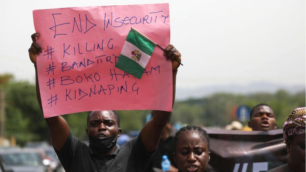 Parents and relatives of abducted students from a different school hold placards during a demonstration in Abuja