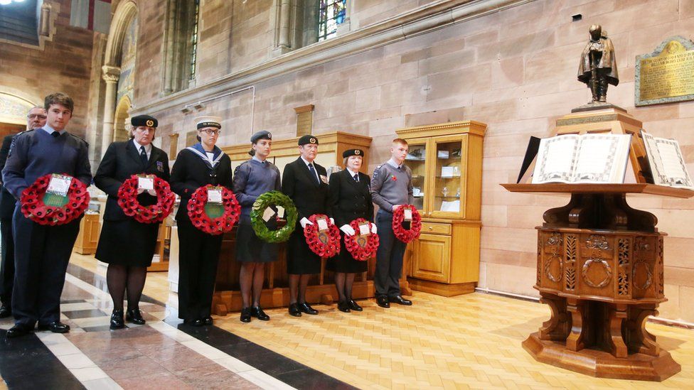 Members of the armed forces wait to lay wreaths during the service