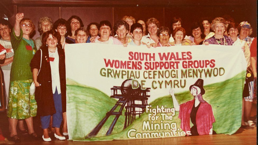 Women holding banner