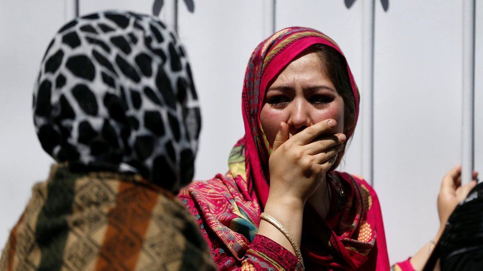 Relatives of Afghan victims mourn outside a hospital after a blast in Kabul, Afghanistan, 31 May