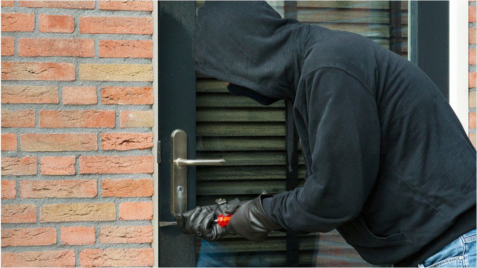 Hooded man attempting break-in