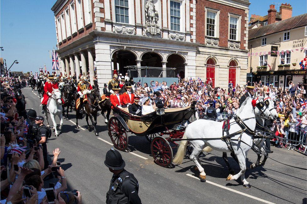 Crowds cheer for Prince Harry, Duke of Sussex, and his wife Meghan, Duchess of Sussex