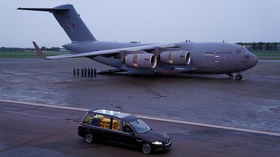 The hearse carrying the Queen's coffin drives away from the plane that flew it from Edinburgh to RAF Northolt