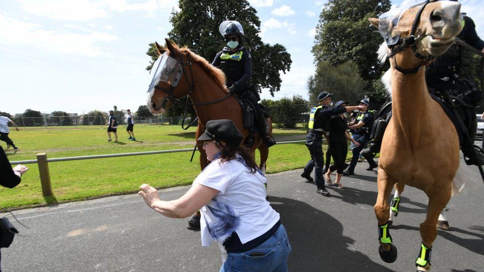 Police try to intercept protesters during an anti-lockdown protest in Melbourne, Australia, 19 September 2020