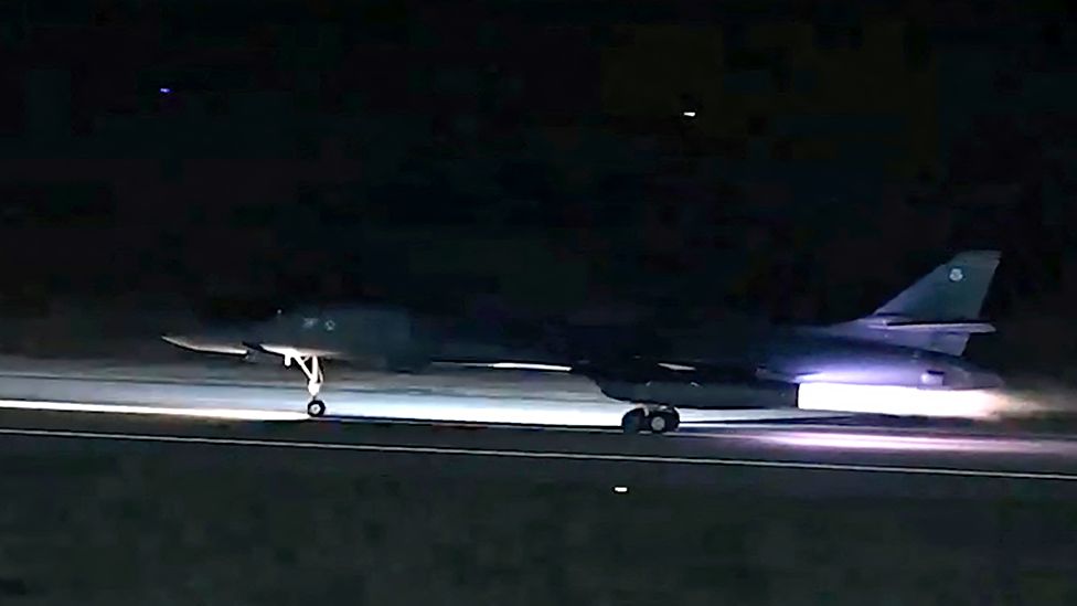 A B-1 bomber taking off from a runway in the dark