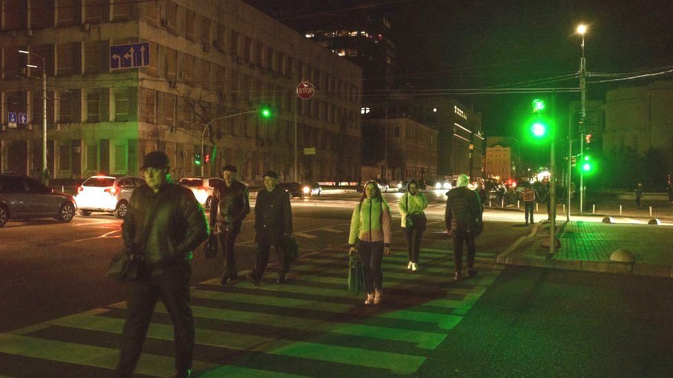 People cross a zebra crossing during an electrical blackout in Kyiv on 31 October