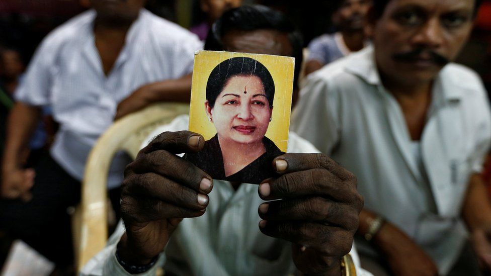 A supporter of Tamil Nadu Chief Minister Jayalalitha Jayaraman holds her photo at the AIADMK party office in Mumbai, India, December 5