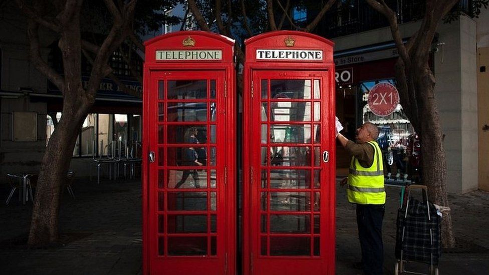 Man cleaning telephone boxes in Gibraltar
