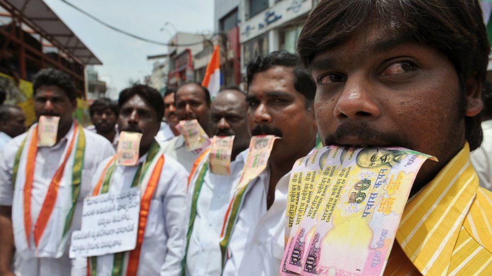 Supporters of Indian social activist Anna Hazare, including members of the Telugu Desam Party (TDP), pose with fake rupee notes signifying corruption during a rally in Hyderabad on August 17, 2011.