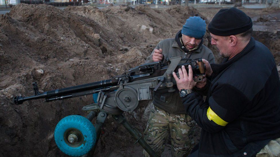 Members of the territorial defense battalion set up a machine gun and organise a military redoubt on 25 February in Kyiv