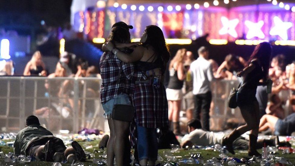 people hugging during Las Vegas attack, others ducked and fleeing