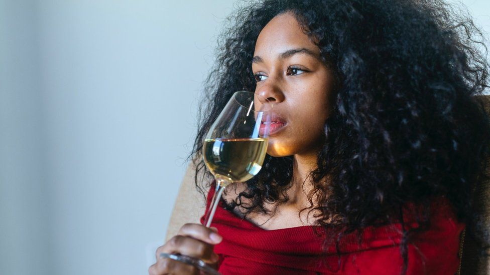 Женщина пьет бокал вина