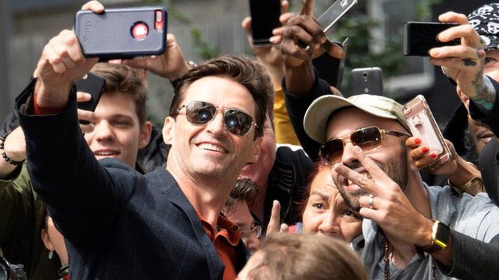 Hugh Jackman takes a selfie with fans