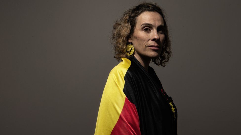 Laura Thompson wearing an Aboriginal flag draped around her shoulders