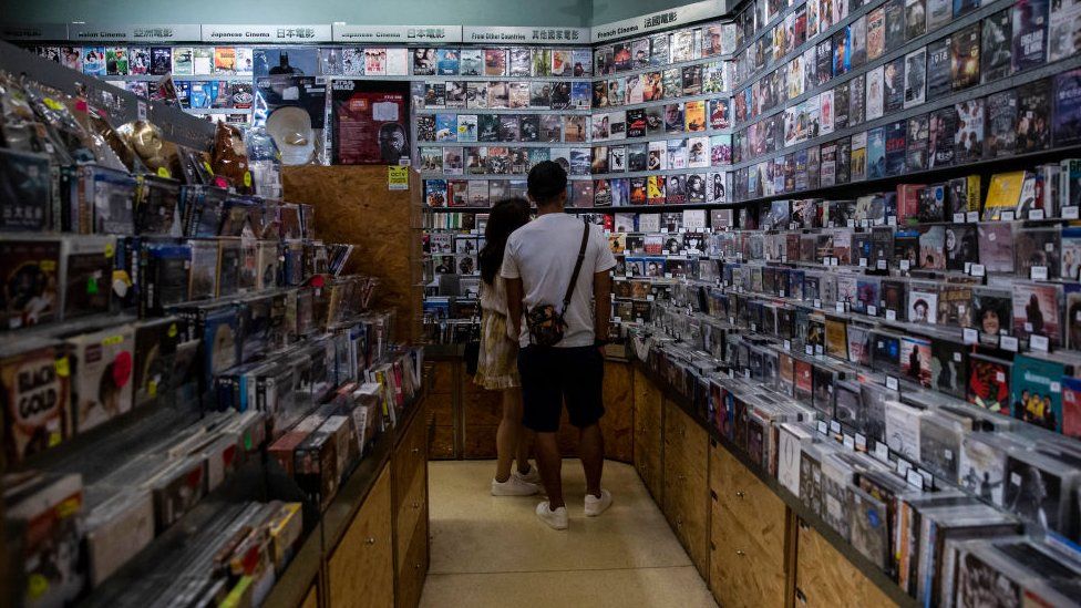 Customers looking at movies for sale at a store inside a cinema in Hong Kong on 2 September