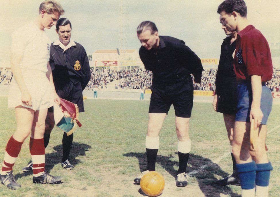 Old picture of Bill in an England kit with an opposing player and referee doing a coin toss