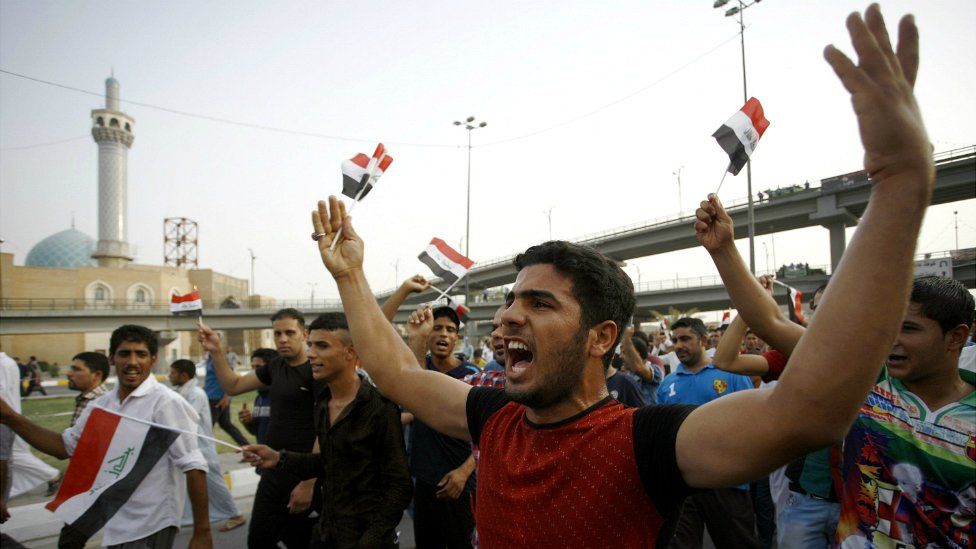 Iraqi men shout slogans and wave flags during a demonstration against corruption and poor services in Najaf - 7 August 2015