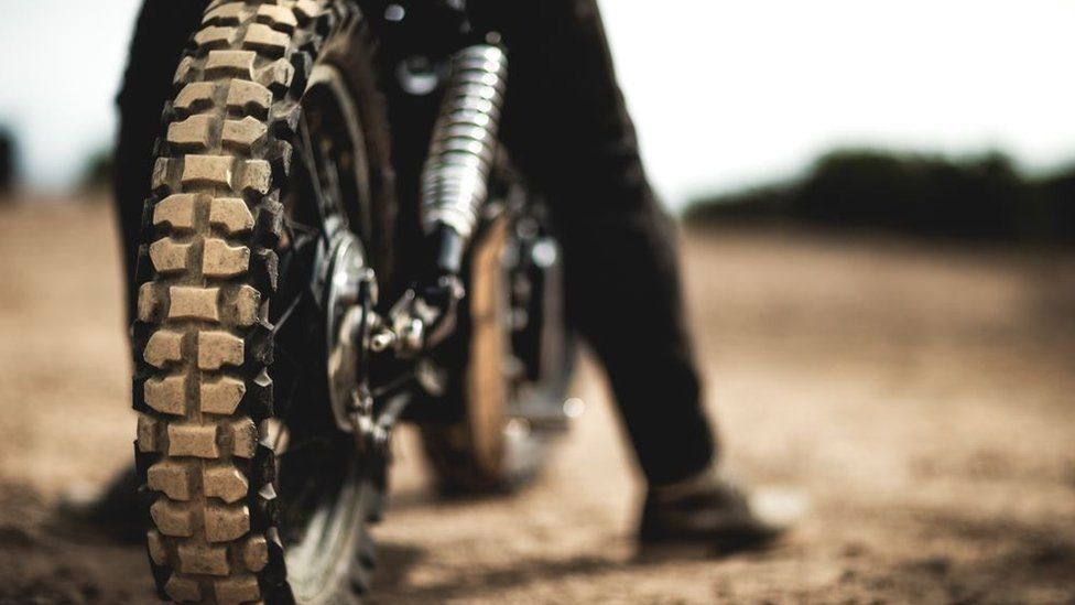 A close up of a motorbike on a dirt track