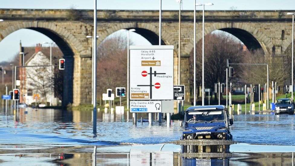 A man drives through the flood-waters on Kirkstall Road in central Leeds on December 27
