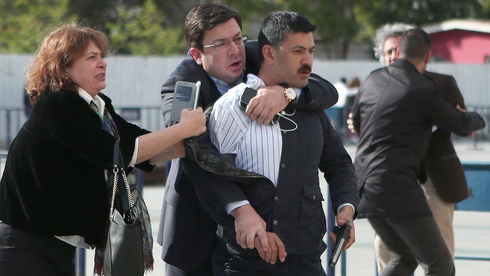 This picture released by Turkish Cumhuriyet Daily newspaper shows Dilek Dundar (L), the wife of editor-in-chief of Turkish newspaper Cumhuriyet daily Can Dundar, trying to stop a gunman as Can Dundar (R) is protected by another man on May 6, 2016 in Istanbul.