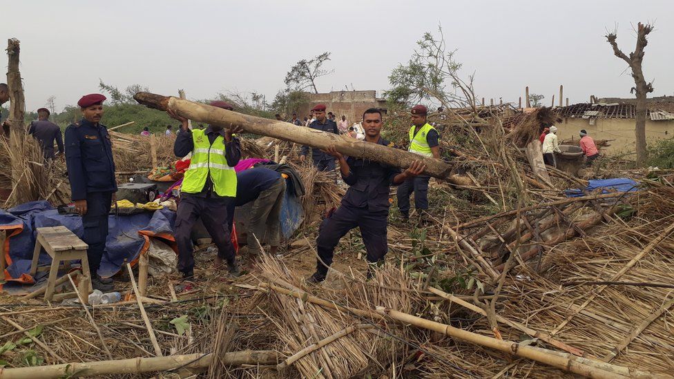 Nepalese police search damaged homes after a storm struck Managadwa village in Bara district, Nepal, 1 April 2019
