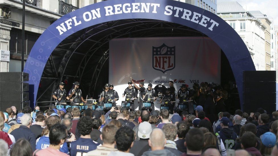 LONDON UK - SEPTEMBER 27: Crowded Regent Street With Jaguars Inflatable  Arch And NFL Flags Above. September 27 2014 In London. The Street Was  Closed To Traffic To Host NFL Related Games