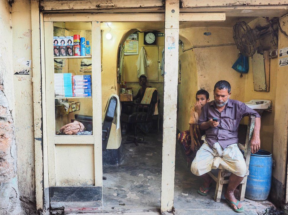 Bangladesh, 2014. Men sit in a hair salon.