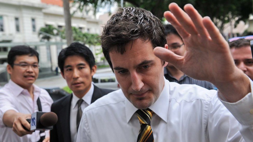 Swiss software consultant Oliver Fricker tries to avoid the media as he walks to the Subordinate court in Singapore on June 24, 2010.