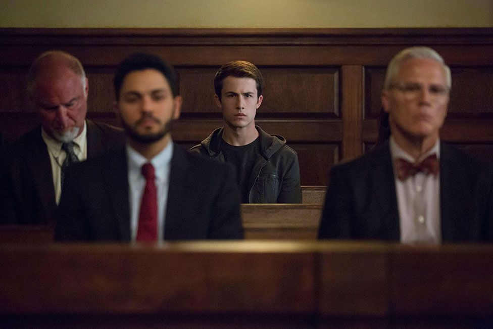 Main character Clay Jensen sits in a courtroom