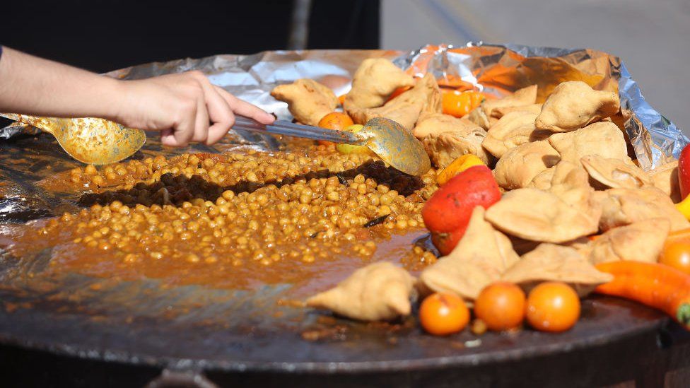 Южноазиатские блюда готовятся на уличном фестивале в Торонто 23 июля.