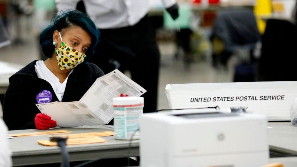 An election worker checks a ballot in Detroit, Michigan