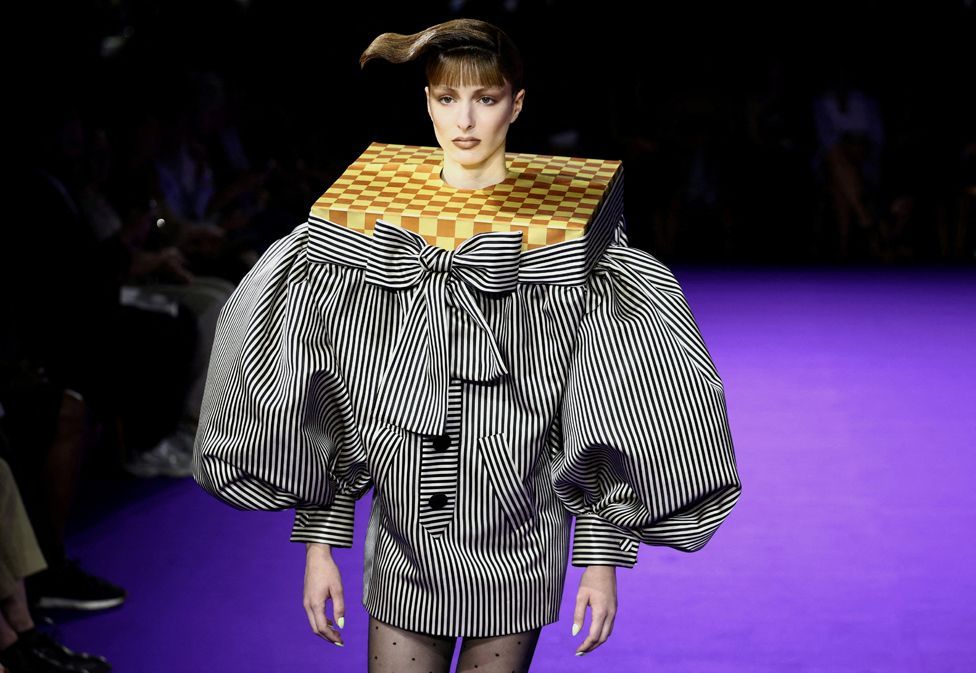 A model presents a creation of a black and white stripe jacket with puff sleeves, accentuated shoulders which a neck piece resembling a chess board,  for the Haute Couture Fall/Winter 2024-2025 collection show for fashion house Viktor & Rolf in Paris, France