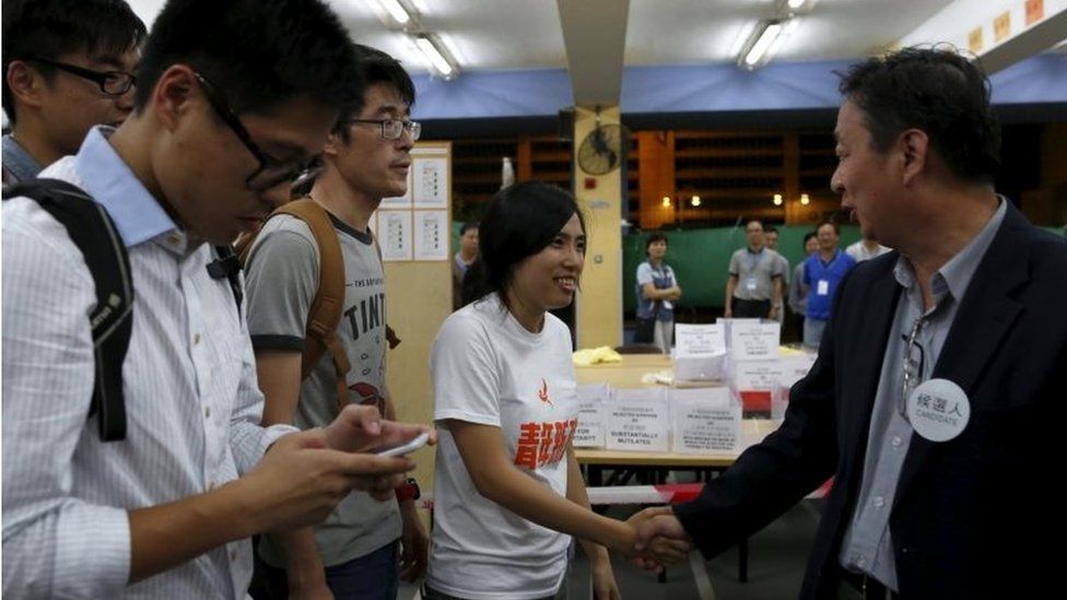 Ms Kwong shakes hands with her opponent in the election