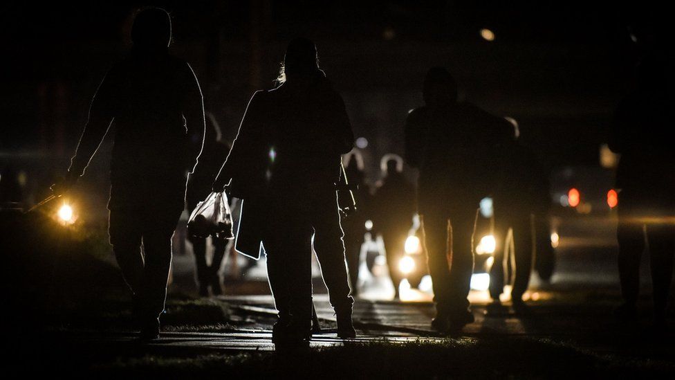 Kyiv residents walk through the city during a rolling power cut