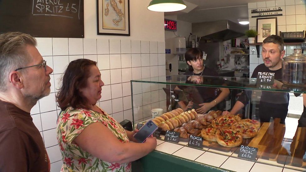 Luca Sanvittore serving customers in his cafe